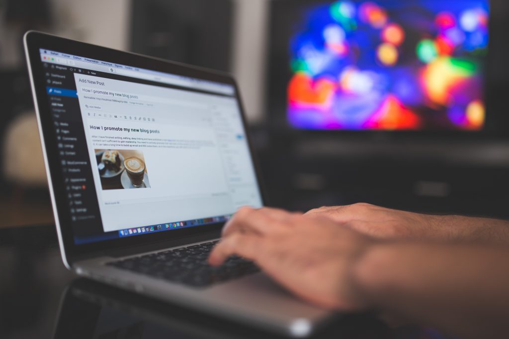 22 group employee typing away on their laptop, writing a blog post for a client