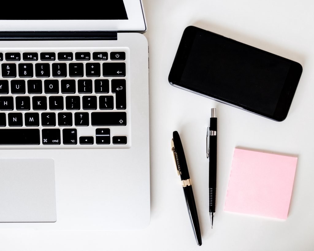 laptop, phone and pen ready to make notes for making some business changes